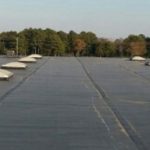 Industrial roofing for asphalt flat roof repair and metal roof transition repair.